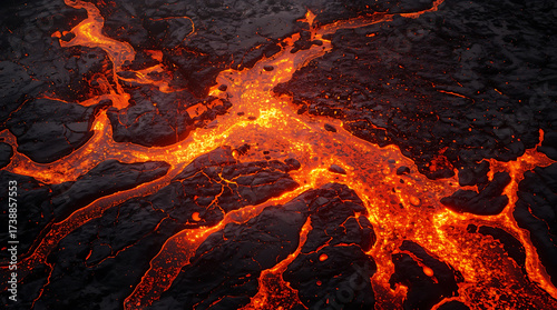 Molten, vibrant orange and red lava bubbling and aggressively spilling over a black surface.
