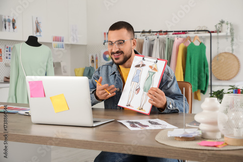 Happy male stylist with lap...