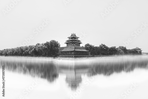 Wallpaper Mural A serene view of a historical structure in Beijing, China, reflected in tranquil water. The ancient architecture, surrounded by trees, exudes peace. The monochrome captures the timeless beauty. Torontodigital.ca