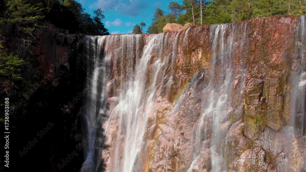tilt up con dron de la Cascada de Cusárare serca de el pueblo de creel en el estado de Chihuahua México, verano con cielo azul, cascada en medio del bosque
