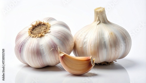 Two garlic bulbs and three peeled cloves rest on a white surface—papery skin meets smooth flesh in quiet contrast. A metaphor for potency and the choreography of transformation through layered simplic