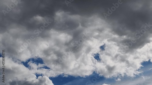 A stunning time-lapse capturing the dynamic movement of fluffy white clouds racing across a vibrant blue daytime sky. Perfect for background footage, meditation videos, weather content, or projects ne