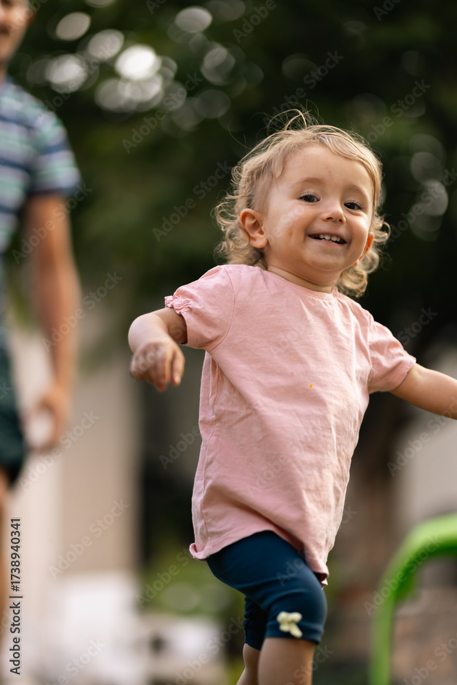 Fototapeta premium Happy child running outdoors in a playful and cheerful mood on a sunny evening