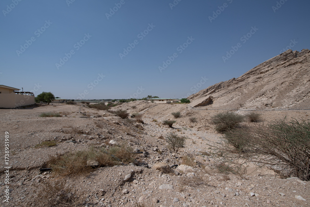 Fototapeta premium Scenic landscapes and mountain roads around Jebel Hafeet in Al Ain, United Arab Emirates, showing desert terrain, rocky hills, and winding routes under clear skies.