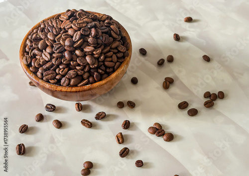 coffee beans in a wooden bowl on a marble table