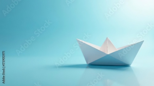 A Simple White Origami Boat on a Smooth, Light Blue Surface, Representing Childhood Dreams and the Journey of Life