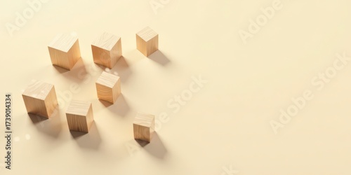 Wooden blocks arranged asymmetrically on a pale yellow background, showcasing simple geometric shapes and natural light casting soft shadows.