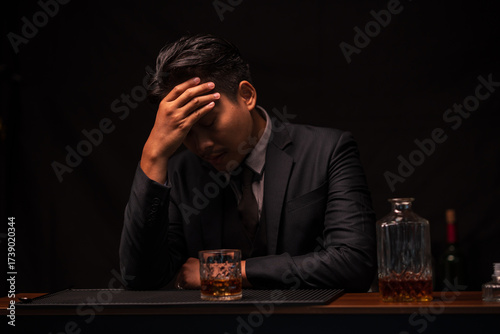 Stressed Businessman Drinking Whiskey Alone at Dark Bar