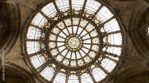 Majestic historic cathedral rose window with intricate stained glass details, illuminating a grand vaulted ceiling, showcasing architectural beauty