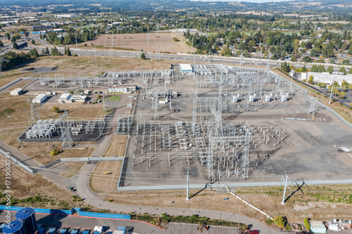 Aerial drone picture of large electric power substation and high voltage power lines in Hillsboro Oregon, showing transmission towers, transformers, and distribution infrastructure from above