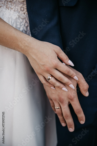 The groom and bride placed their palms on each other, showing off their manicured fingers and gold wedding rings on their wedding day