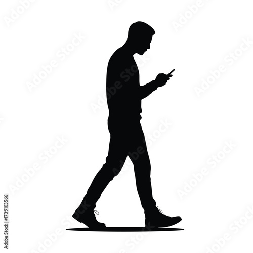 Black silhouette of a man walking while looking at his phone mobile