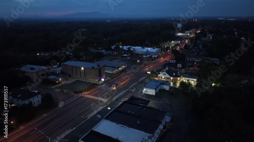 Wallpaper Mural Aerial view of an American suburban street at dusk with glowing streetlights, cars on road and commercial buildings. Trsffic scene in small-town atmosphere of USA. Nightscape in Virginia. Torontodigital.ca
