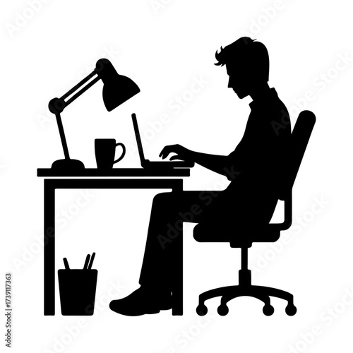 Silhouette of a man working on a laptop at a desk