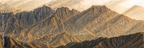 Mountain landscape with dramatic ridges and warm light at sunrise over the peaks in a remote location