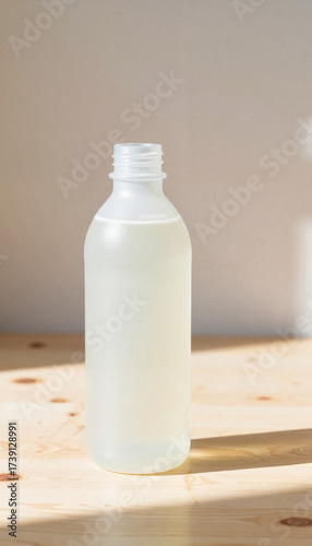 Clear plastic bottle filled with liquid on wooden surface  
