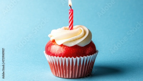 Festive treat red apple cupcake with single lit candle