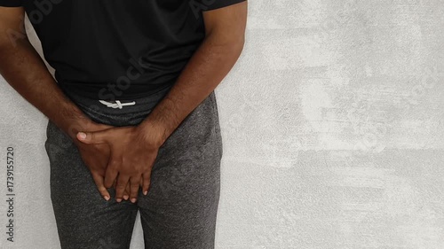Closeup of person hand touches crotch or penis bladder isolated on white background with copy space. Uti, kidney problem, discomfort, pain, ache, urinary disease and penile cancer concept.