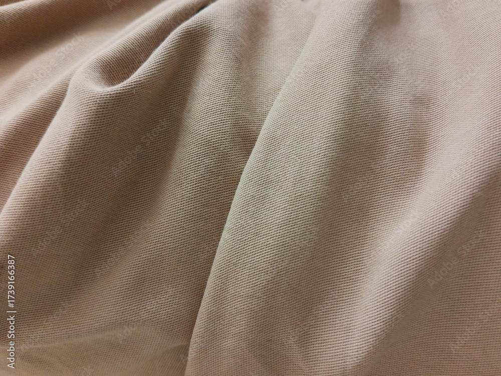 Fototapeta premium beige textile fabric with soft folds and detailed texture. Neutral cotton cloth background suitable for fashion, design, and textile industry themes