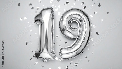 Silver balloon number 19 with confetti on solid colored background. Photo for anniversary or birthday party