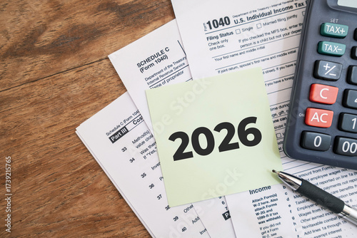 2026 numbers on the note paper with calculator and taxes documents. Marketing materials related to tax filing or fiscal year deadlines