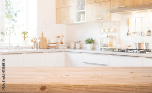 Food presentation background with empty wooden table top in front of blurred modern kitchen workspace interior