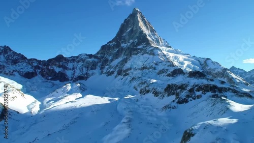 Majestic mountain aerial with snowy peaks and clear blue sky in breathtaking landscape