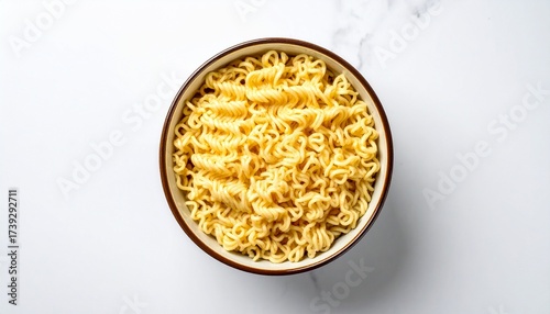 Top down view of uncooked instant ramen noodles in a simple ceramic bowl against a light textured background