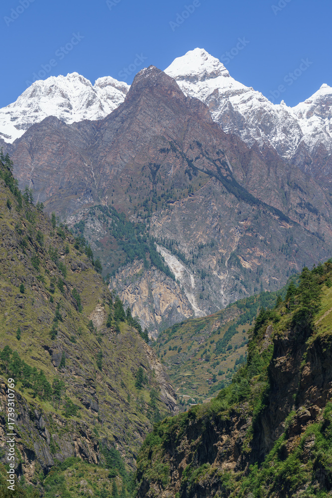 Obraz premium Majestic snow capped mountains rise above green valleys