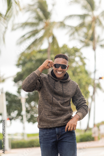 Stylish African American man savoring autumn vibes in Miami, in a hoodie