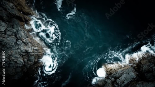 Ocean waves crashing against rocky coastline aerial view