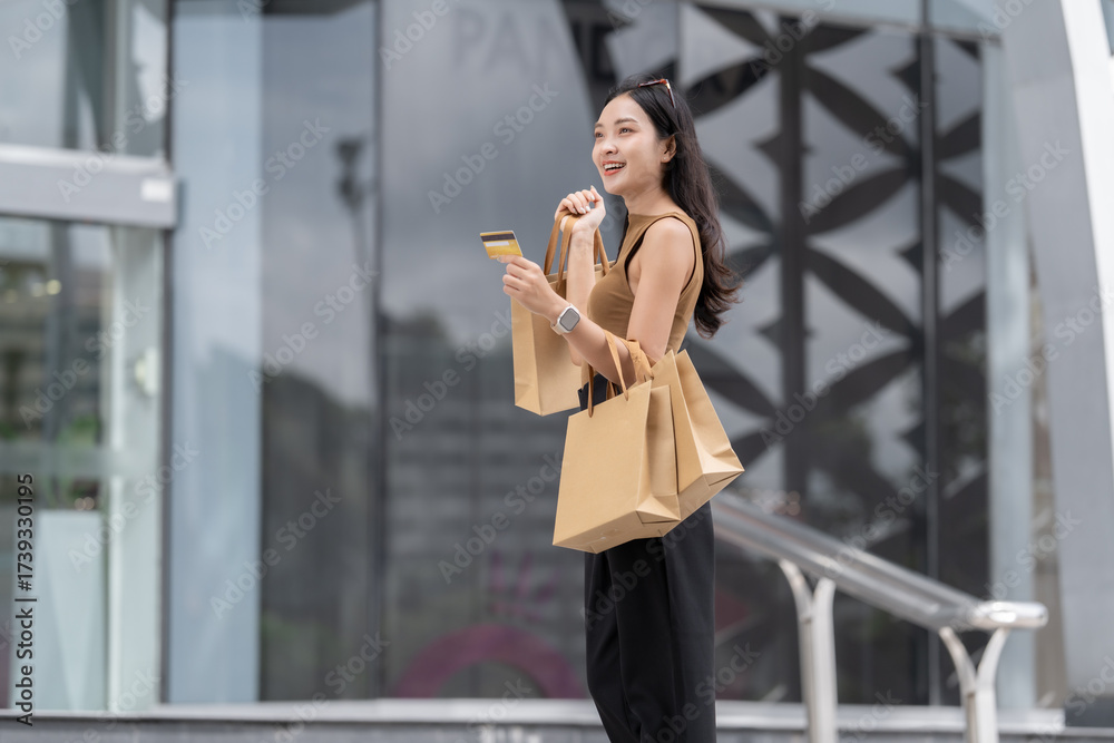 Fototapeta premium Woman enjoying shopping holding credit card and bags