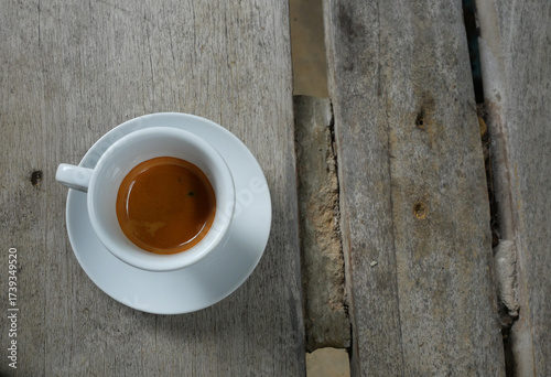 Espresso Coffee in white cup on grey color wooden table , Hot drink on ceramic plate