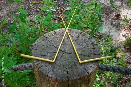Dowsing with metal indicator L rods is a modern tool of a dowser. Two dowsing rods for the radiesthesia technique, lie on the stump of an old tree. An ancient method, not scientifically proven