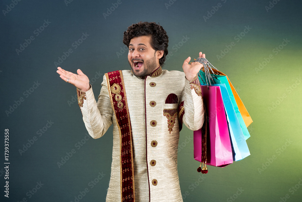 Fototapeta premium Indian traditional Young handsome man holding and posing with shopping bags