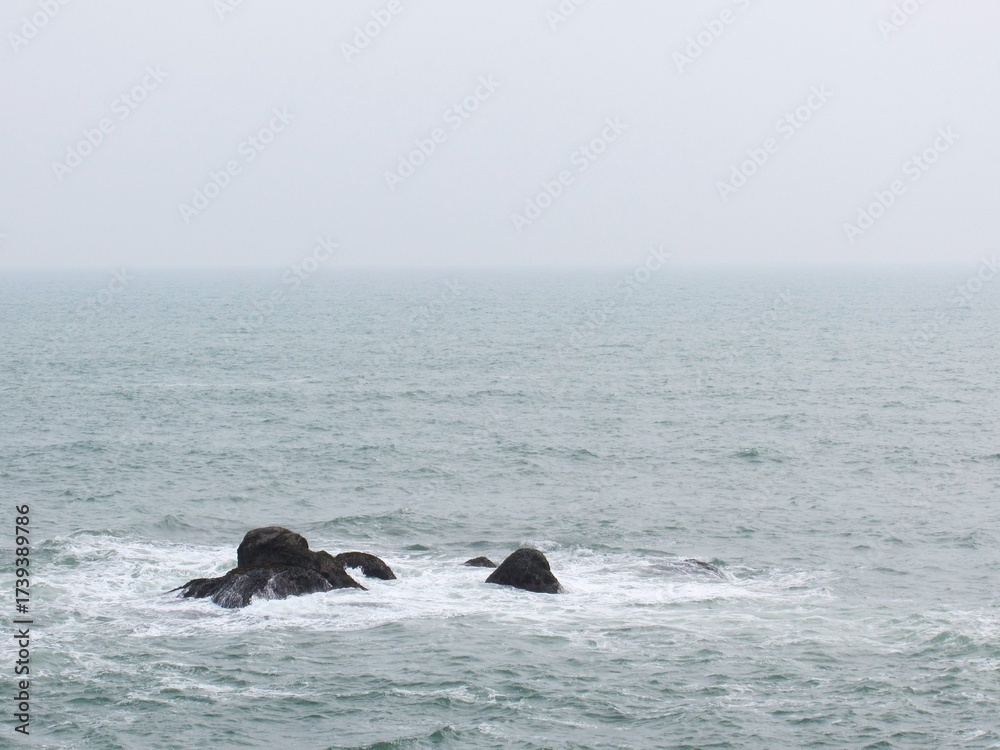 Obraz premium Coastal serenity rocks in the misty ocean. Tranquil seascape nature scene