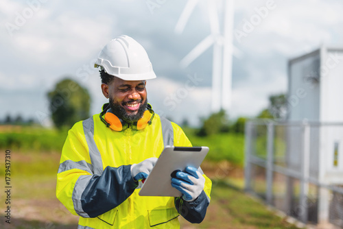 man in  yellow jacket is wearing  hard hat and holding  tablet