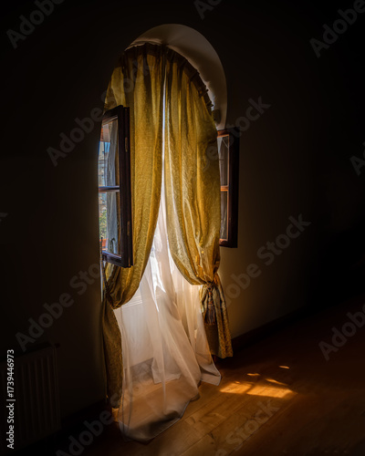 Arched window with curtains and sunlight in interior