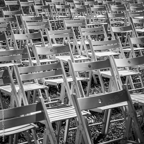 Black and white rows of folding chairs outdoors