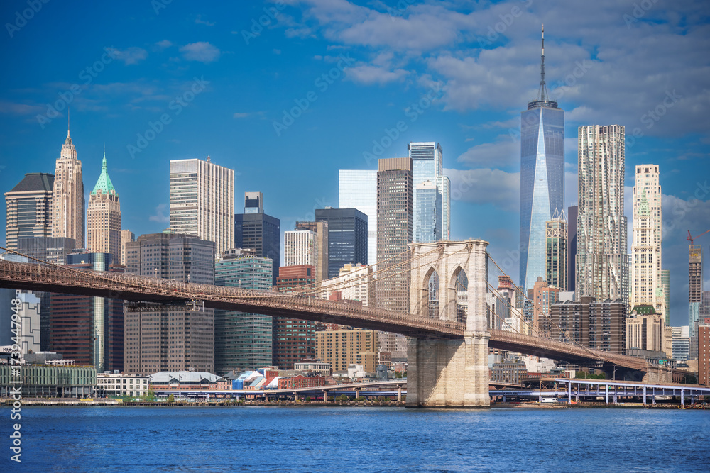 Fototapeta premium Majestic Brooklyn Bridge graces the NYC skyline. Soaring steel arches frame the cityscape, bathed in warm sunlight. Iconic landmark for travel and architecture projects. wallpaper, 4k