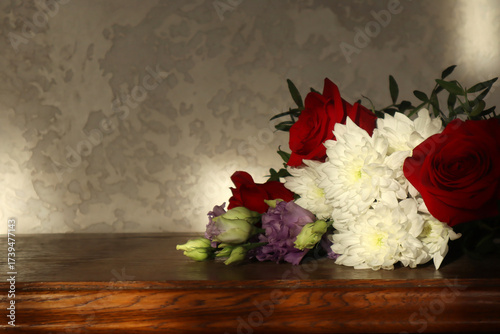 A beautiful bouquet of flowers lies on a wooden chest of drawers. A cozy, homey backdrop.