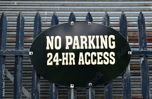 Oval Black Metal No Parking Sign on Steel Fence