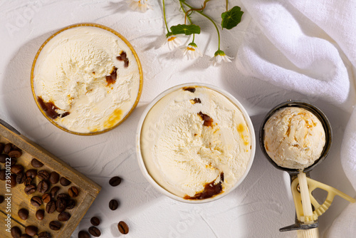 Coffee ice cream tubs on a white background with flowers and coffee beans.