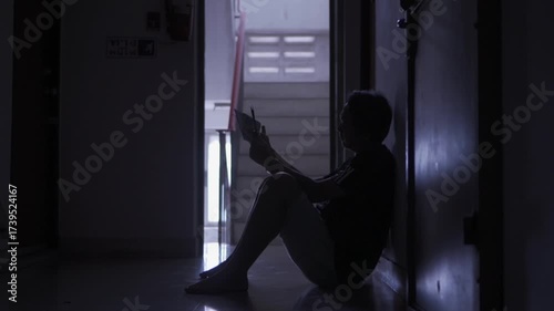 Person Sitting in Dim Hallway, Embracing Shadows of Contemplation and Solitude, Reflecting on Isolation and Introspection Through Emotional Moments
