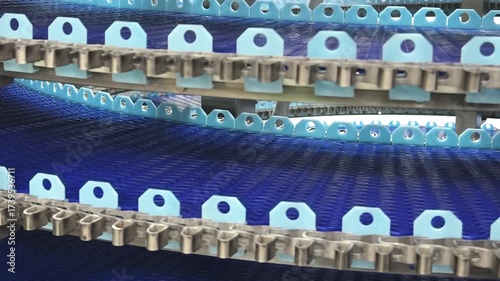 Observation of a conveyor belt system transporting blue components in a manufacturing facility