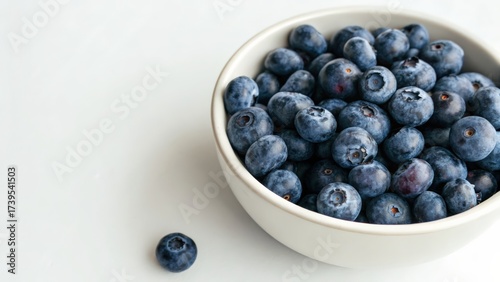 Fresh blueberries in a white bowl on a light background