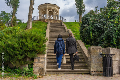 Two women climbing stairs to park pavilion on Ternopil Lake embankment