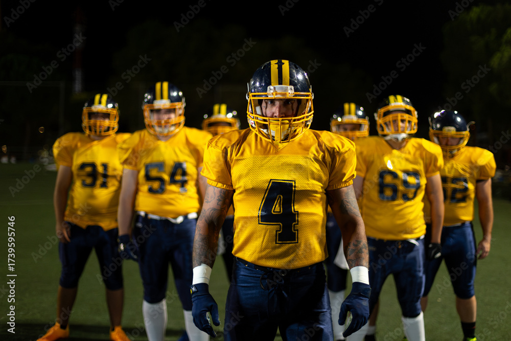 Fototapeta premium Football player with team on field at night