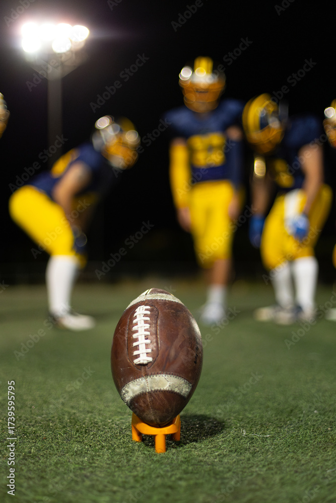 Fototapeta premium Football on tee ready for kickoff at night game