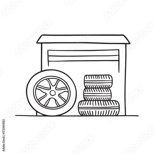 A wheel near a stack of tires placed beside a garage wall